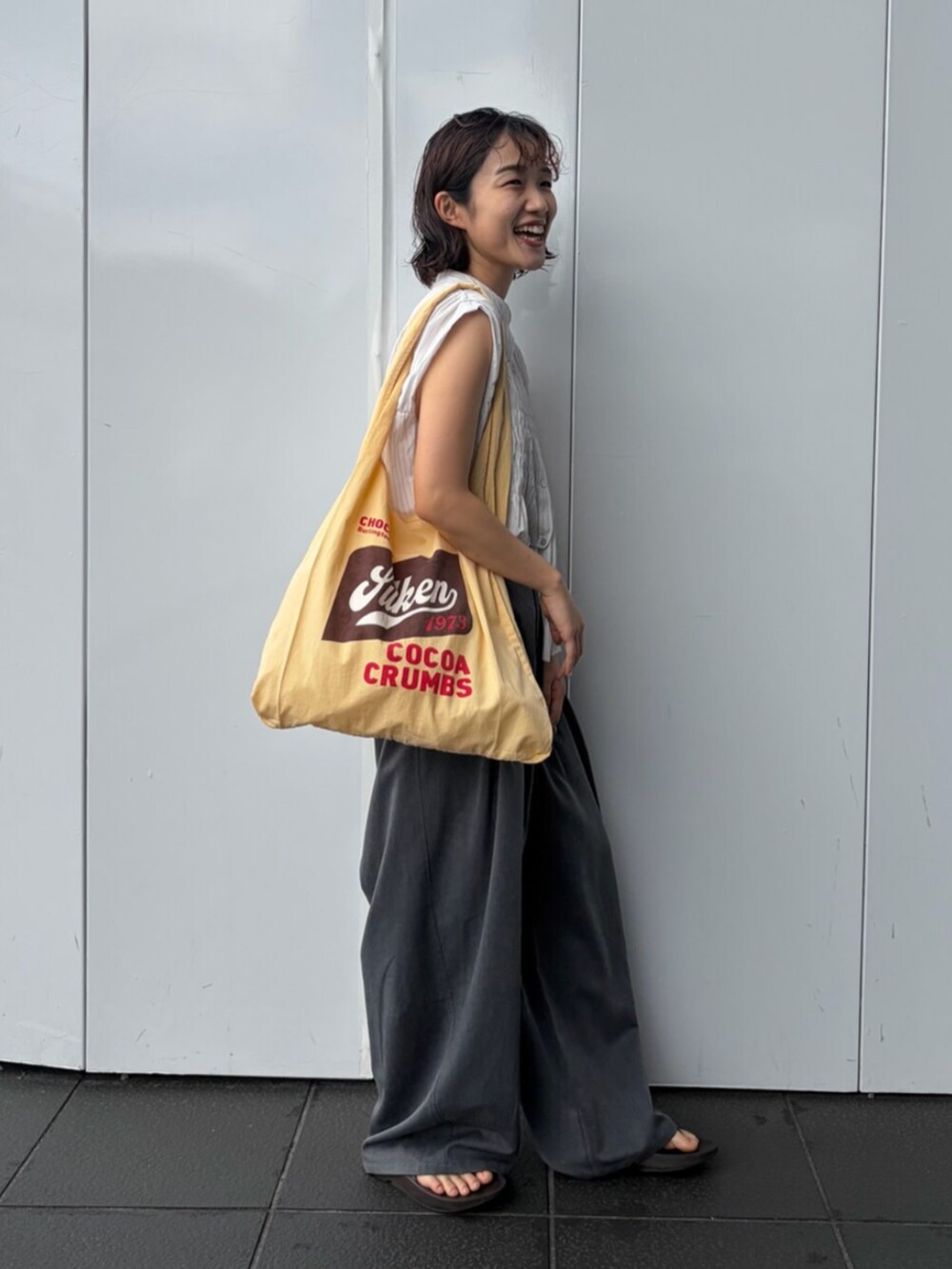 ホワイト系のシャツ/ブラウス、グレー系のその他パンツ、イエロー系のトートバッグを着用したレディースの夏コーディネートの2枚目の写真