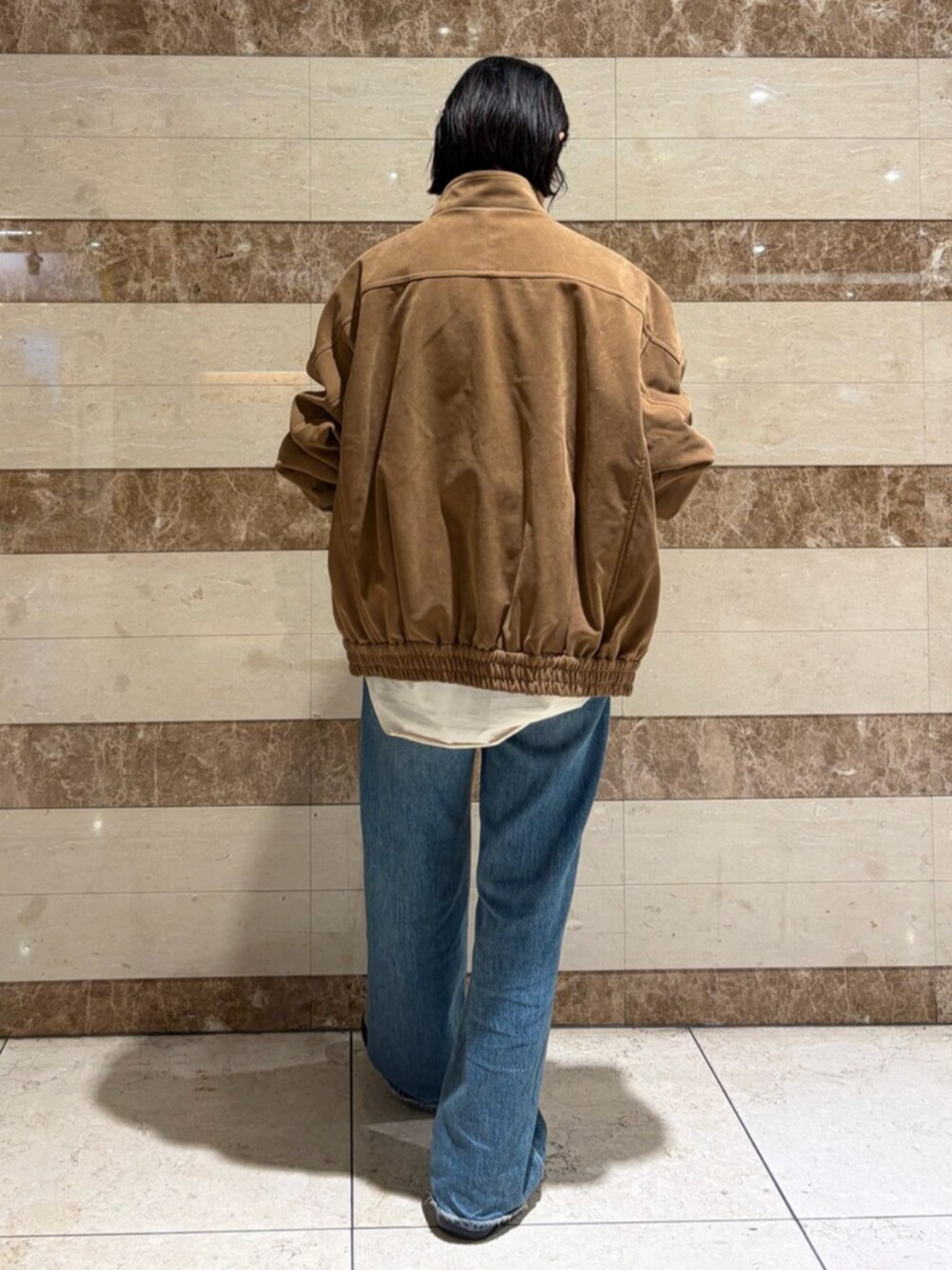 ベージュ系のシャツ/ブラウス、ブラウン系のブルゾン、ブルー系のデニムパンツを着用したレディースの秋コーディネートの3枚目の写真