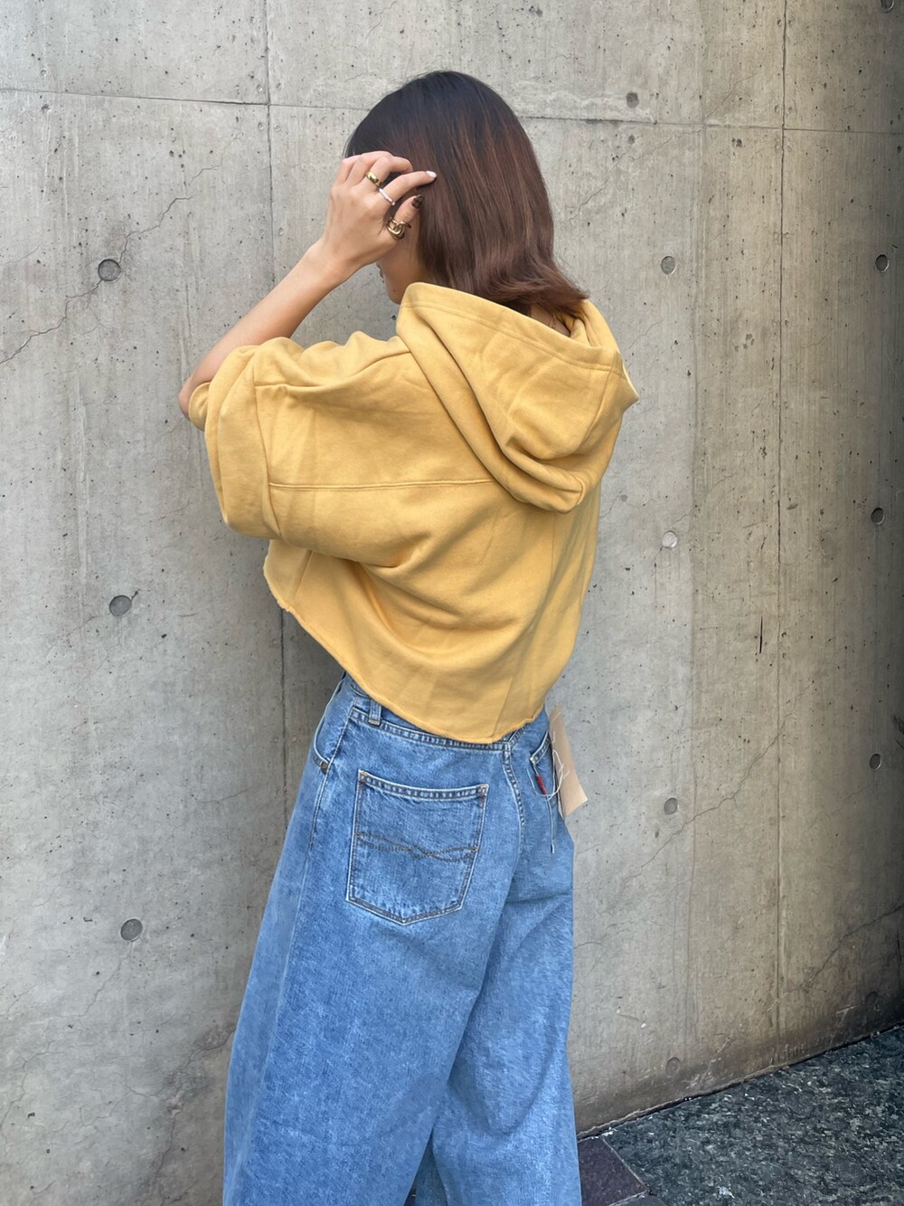 ブルー系のデニムパンツ、イエロー系のパーカーを着用したレディースの秋コーディネートの4枚目の写真