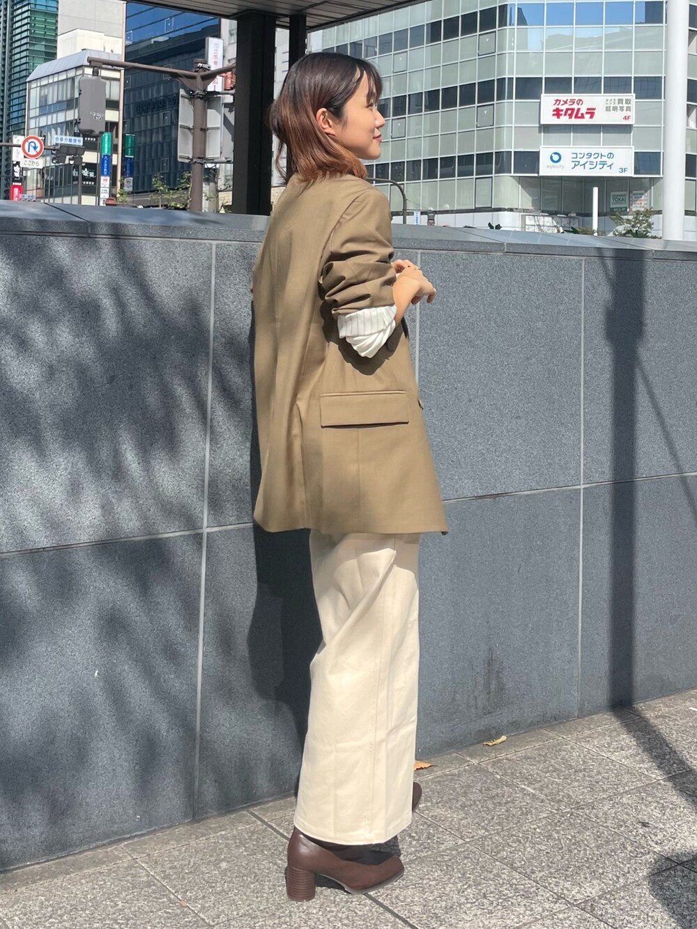 ベージュ系のテーラードジャケット、ホワイト系のTシャツ/カットソー、ベージュ系のスカートを着用したレディースの秋コーディネートの2枚目の写真
