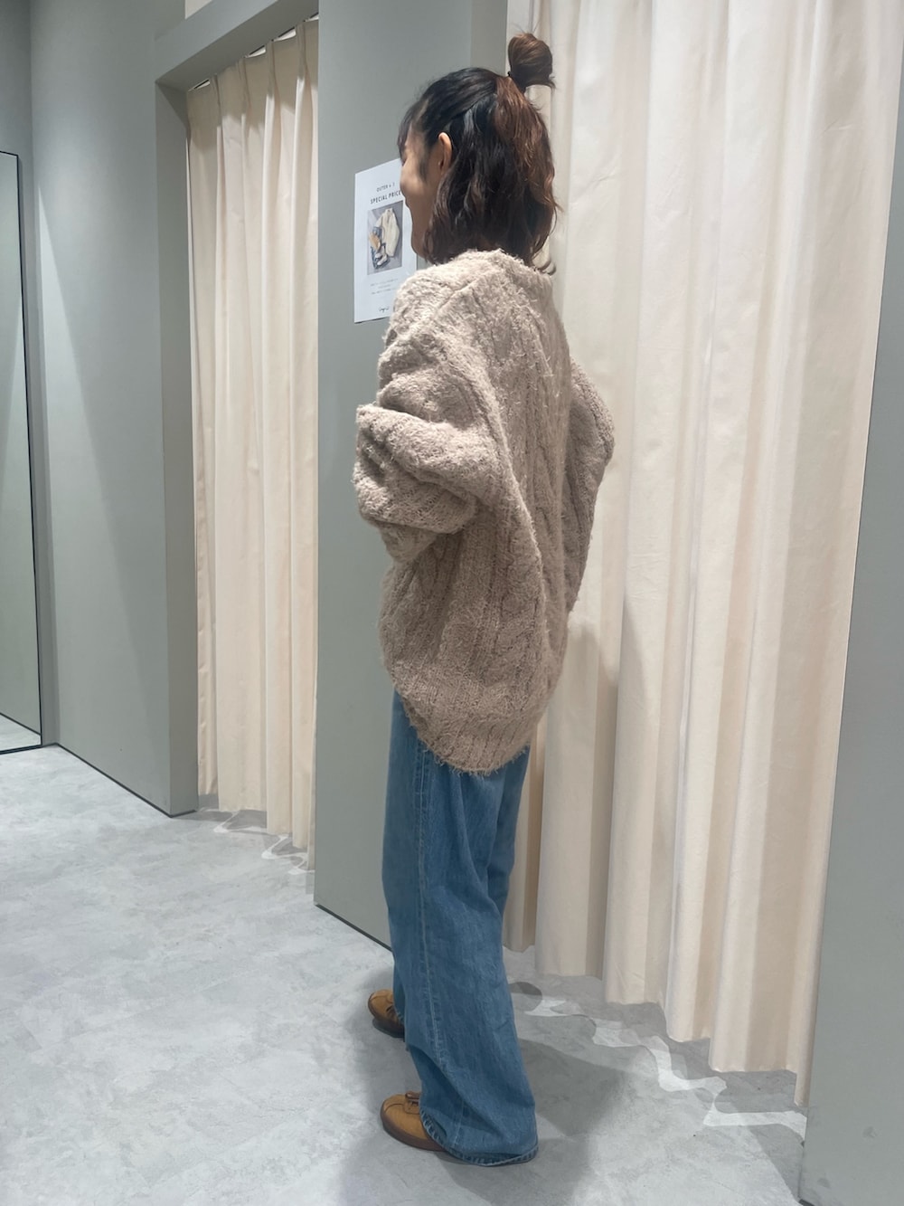 ベージュ系のニット/セーター、ブルー系のデニムパンツを着用したレディースの秋コーディネートの3枚目の写真