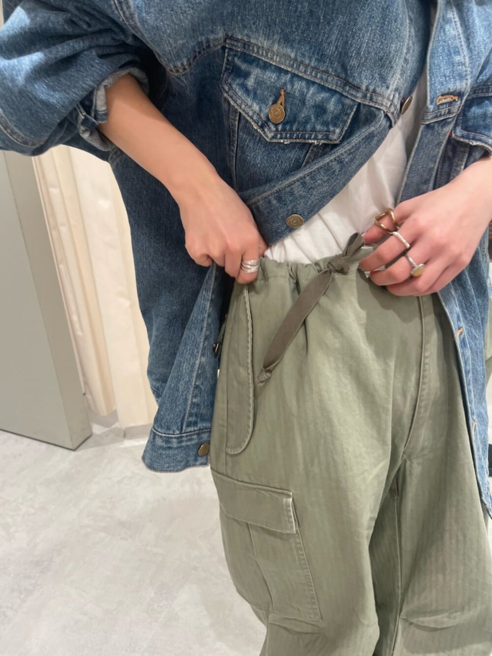 ブルー系のデニムジャケット、グリーン系のその他パンツ、ブラック系のスニーカーを着用したレディースの春コーディネートの5枚目の写真