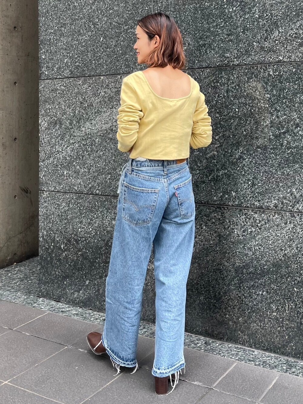 グリーン系のTシャツ/カットソー、ブルー系のデニムパンツ、ブラウン系のブーツを着用したレディースの秋コーディネートの3枚目の写真