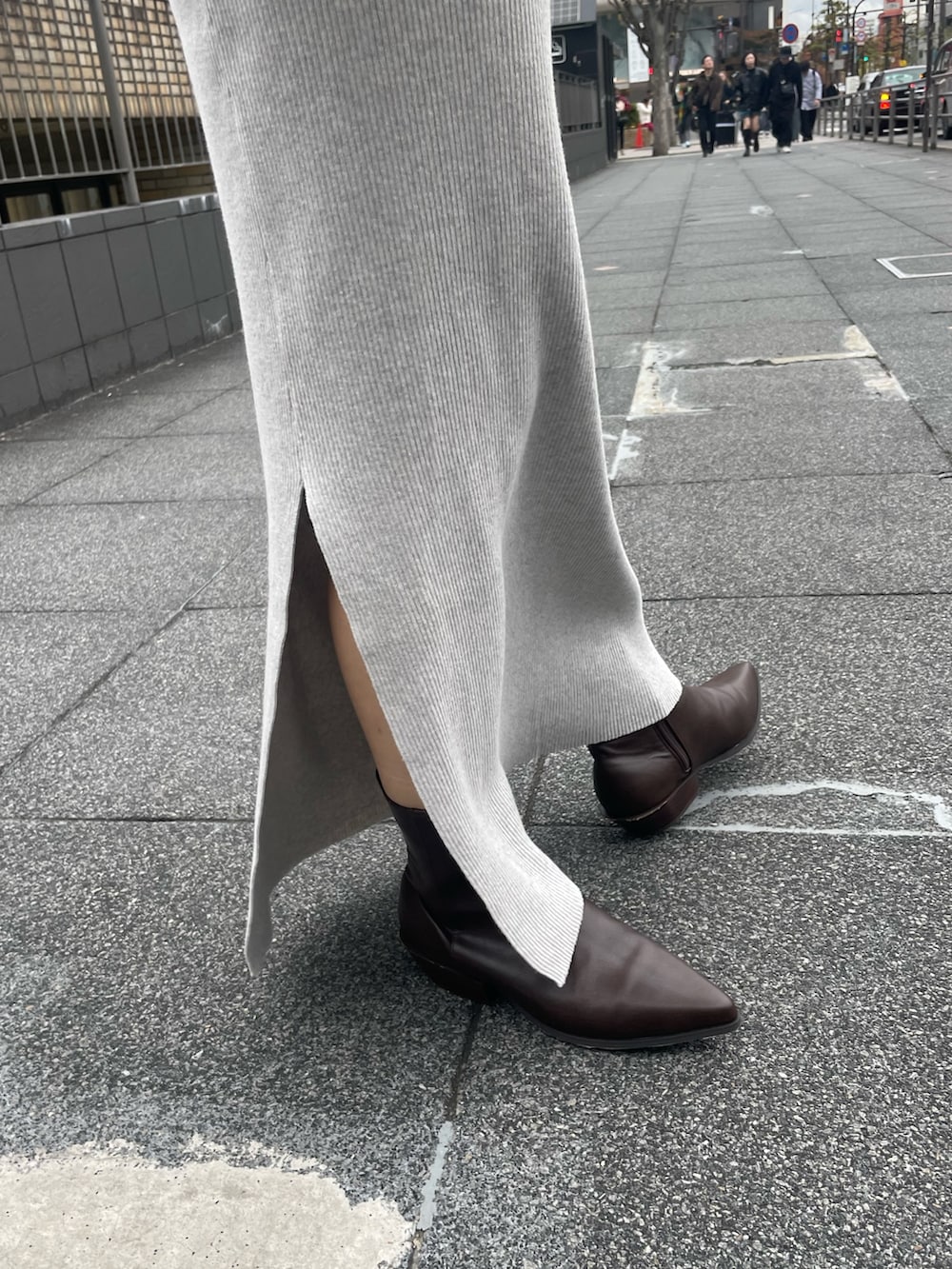 ホワイト系のブルゾン、オレンジ系のニット/セーター、グレー系のスカートを着用したレディースの冬コーディネートの7枚目の写真