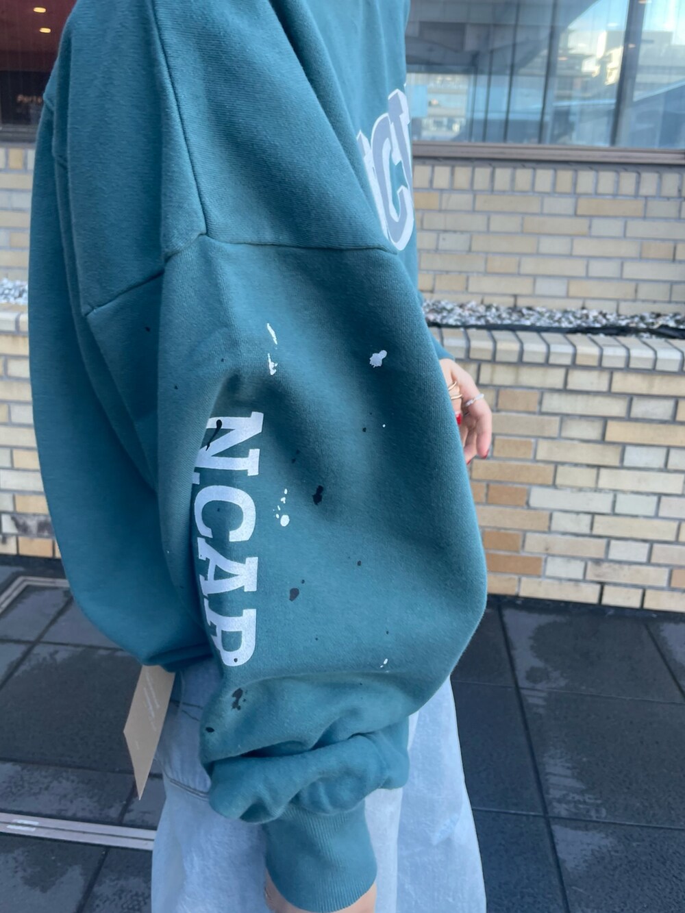 グリーン系のスウェット、ブルー系のデニムパンツを着用したレディースの冬コーディネートの4枚目の写真