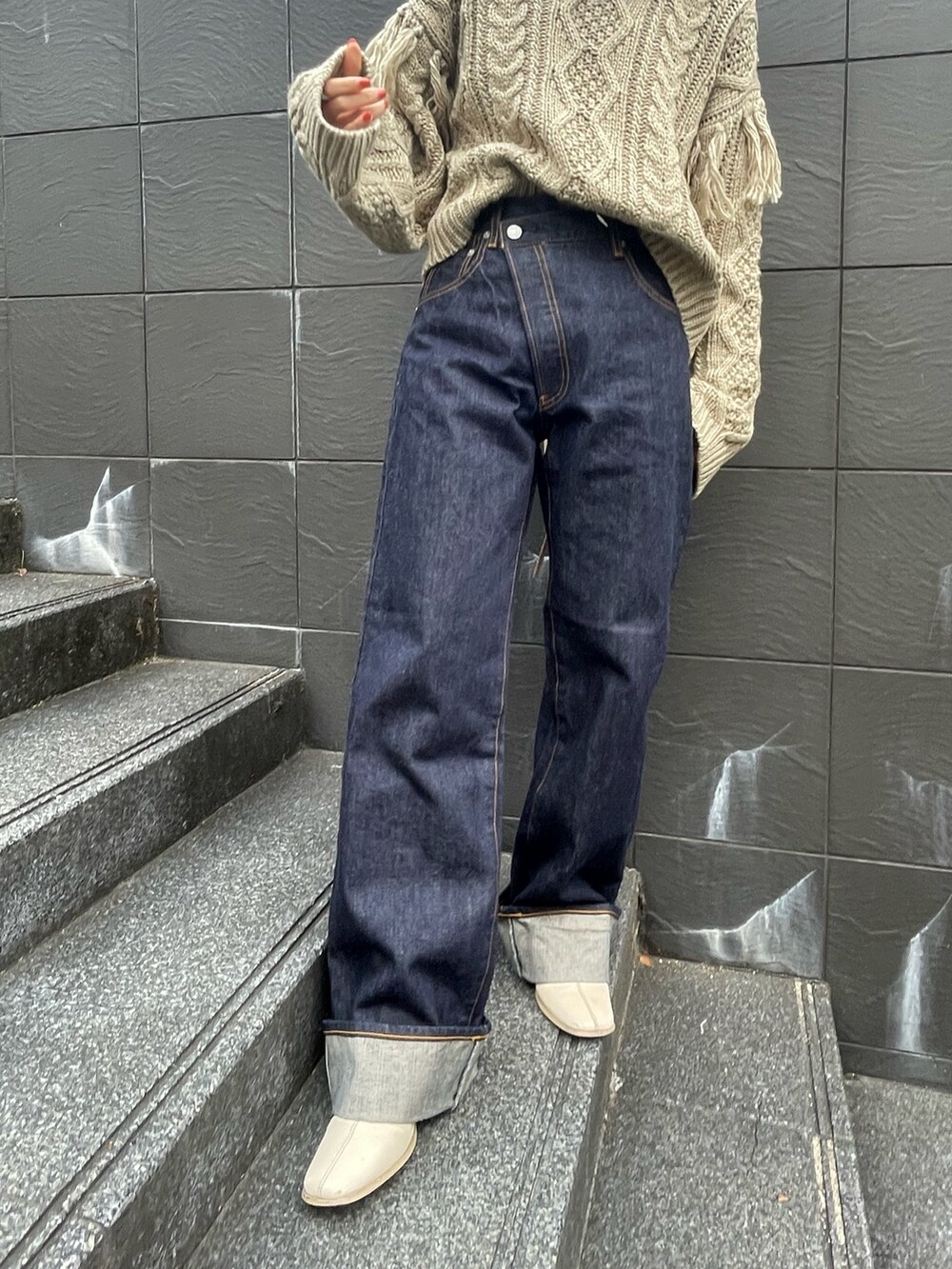 ベージュ系のニット/セーター、ブルー系のデニムパンツを着用したレディースの冬コーディネートの5枚目の写真