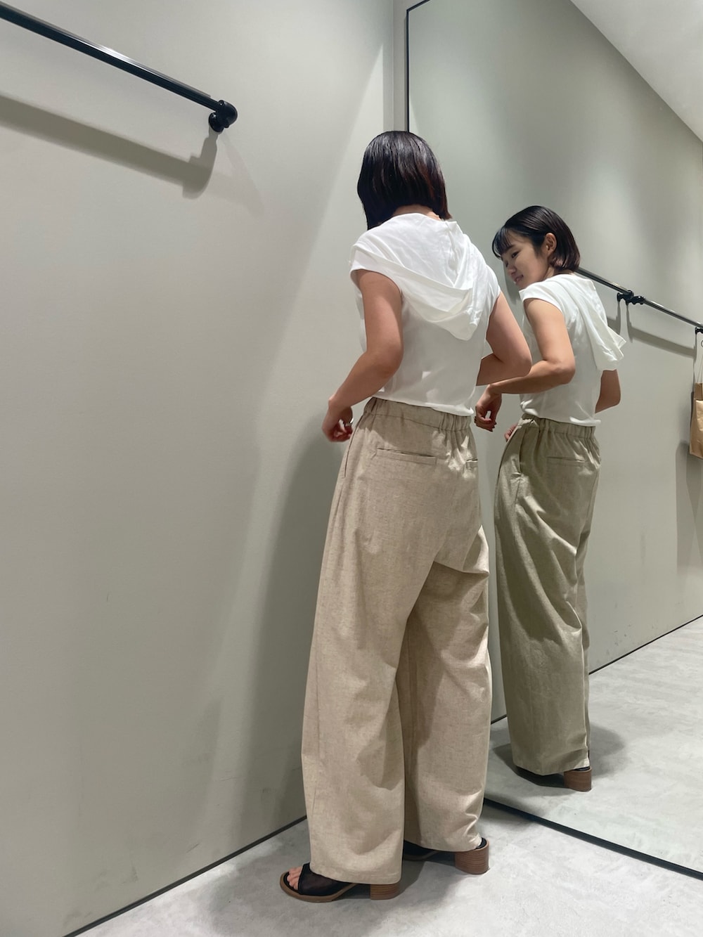 ホワイト系のTシャツ/カットソー、ベージュ系のその他パンツ、ブラック系のサンダルを着用したレディースの夏コーディネートの2枚目の写真