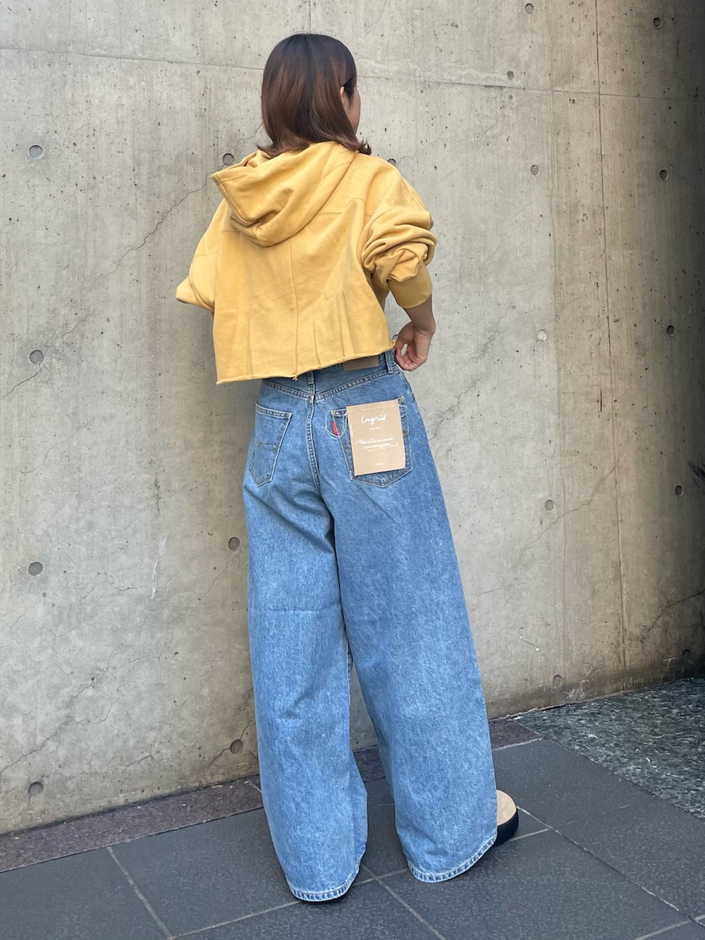 ブルー系のデニムパンツ、イエロー系のパーカーを着用したレディースの秋コーディネートの3枚目の写真