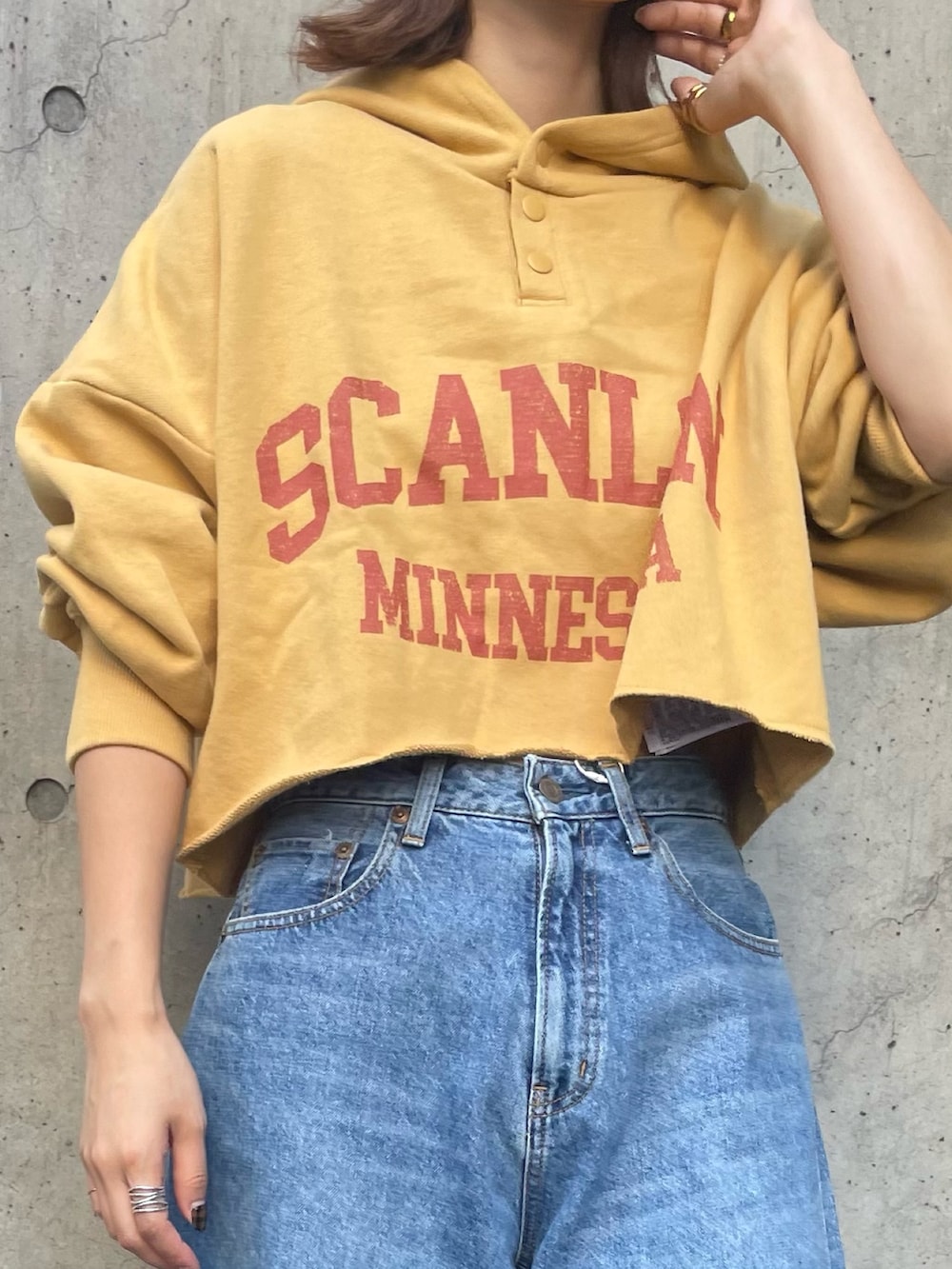 ブルー系のデニムパンツ、イエロー系のパーカーを着用したレディースの秋コーディネートの5枚目の写真