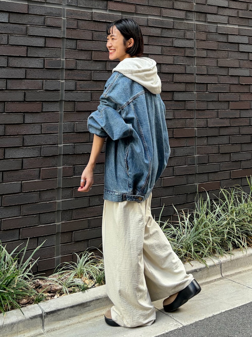 ブルー系のデニムジャケット、ホワイト系のその他パンツ、ホワイト系のパーカーを着用したレディースの秋コーディネートの2枚目の写真