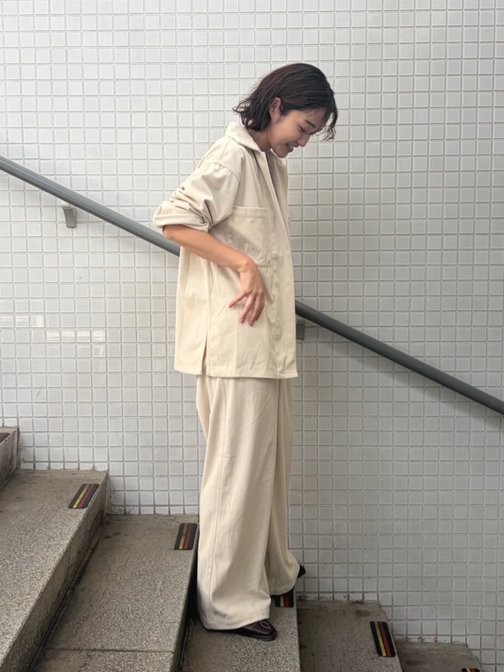 パープル系のタンクトップ、ホワイト系のブルゾン、ホワイト系のその他パンツを着用したレディースの夏コーディネートの2枚目の写真