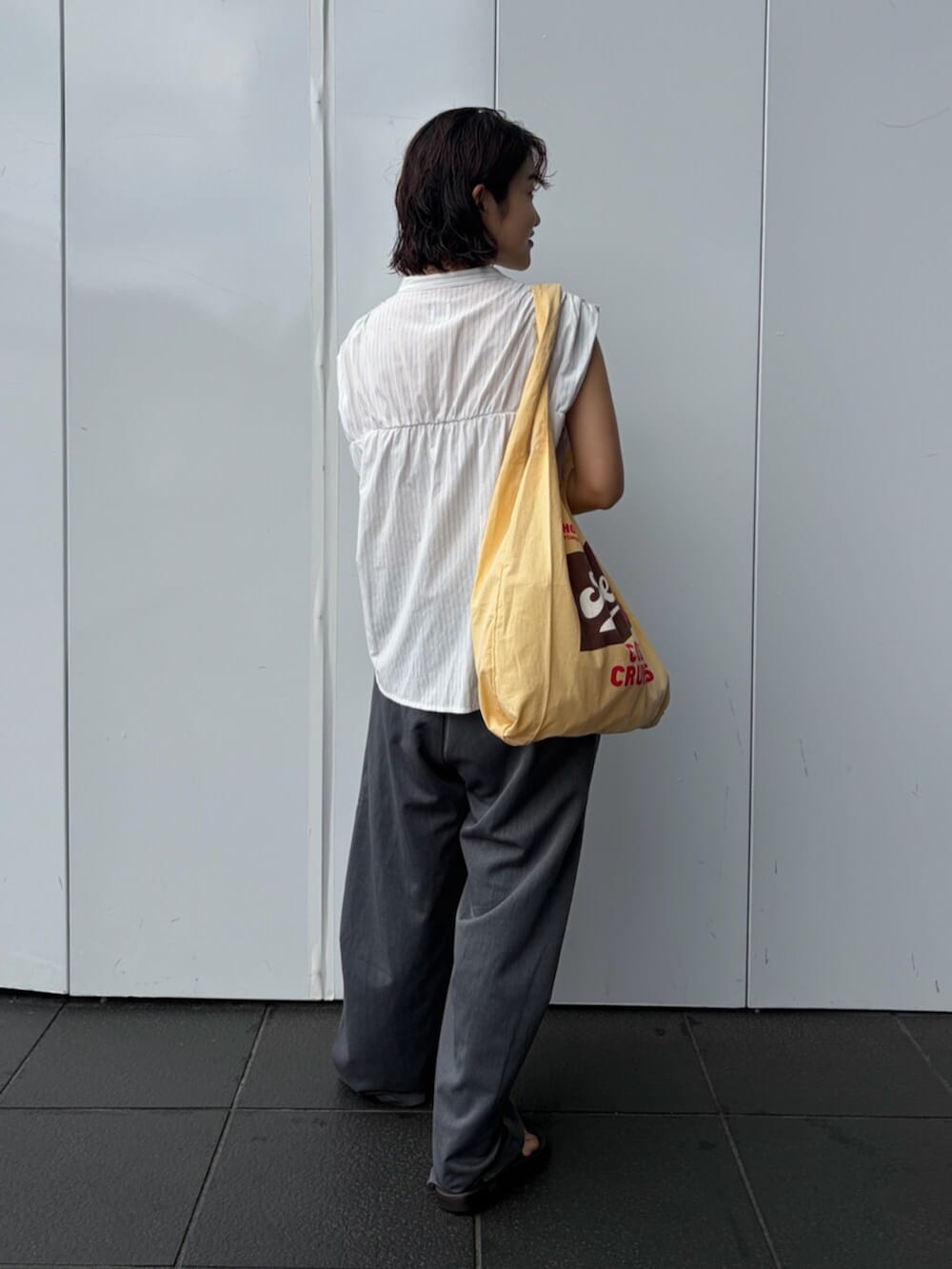 ホワイト系のシャツ/ブラウス、グレー系のその他パンツ、イエロー系のトートバッグを着用したレディースの夏コーディネートの3枚目の写真