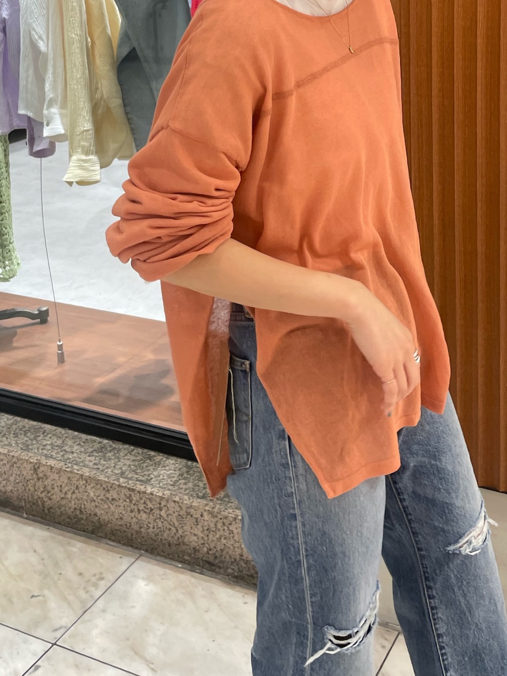 オレンジ系のニット/セーター、ブルー系のデニムパンツ、シルバー系のバレエシューズを着用したレディースの春コーディネートの4枚目の写真