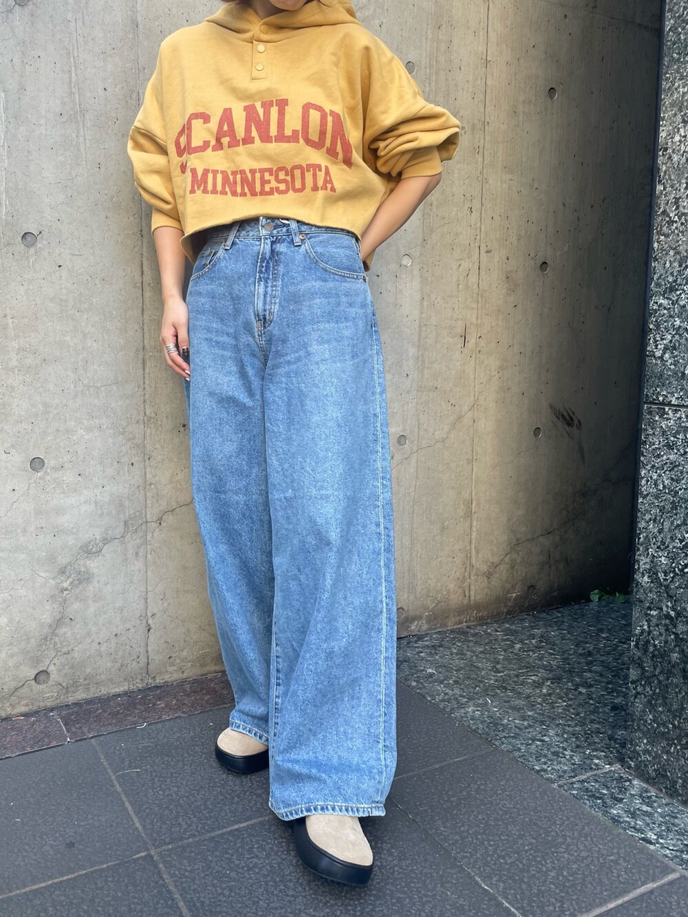 ブルー系のデニムパンツ、イエロー系のパーカーを着用したレディースの秋コーディネートの6枚目の写真