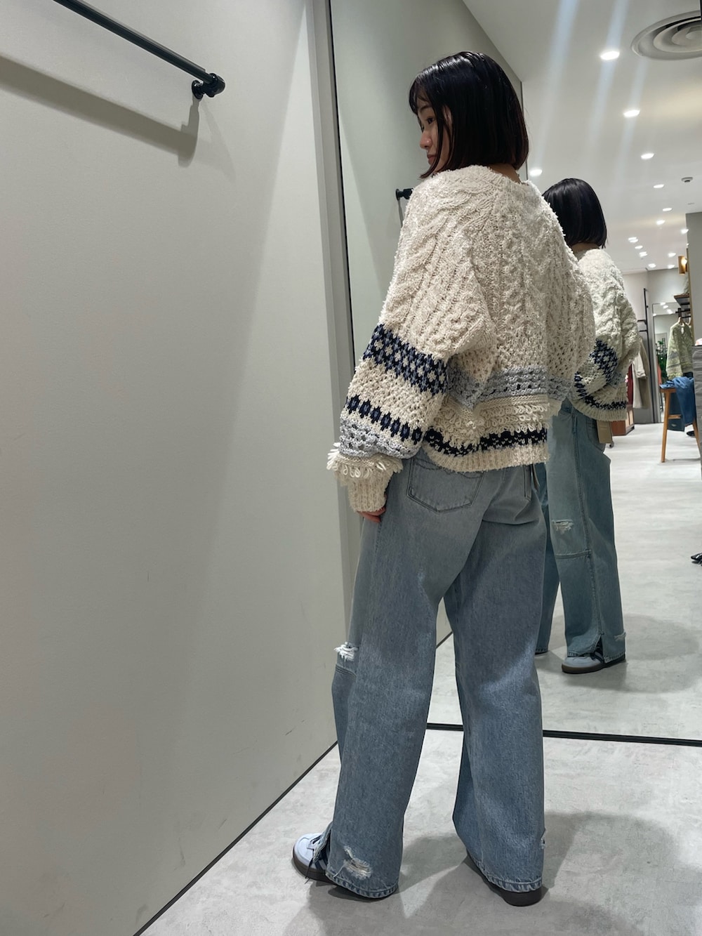 ホワイト系のニット/セーター、ブルー系のデニムパンツを着用したレディースの冬コーディネートの2枚目の写真