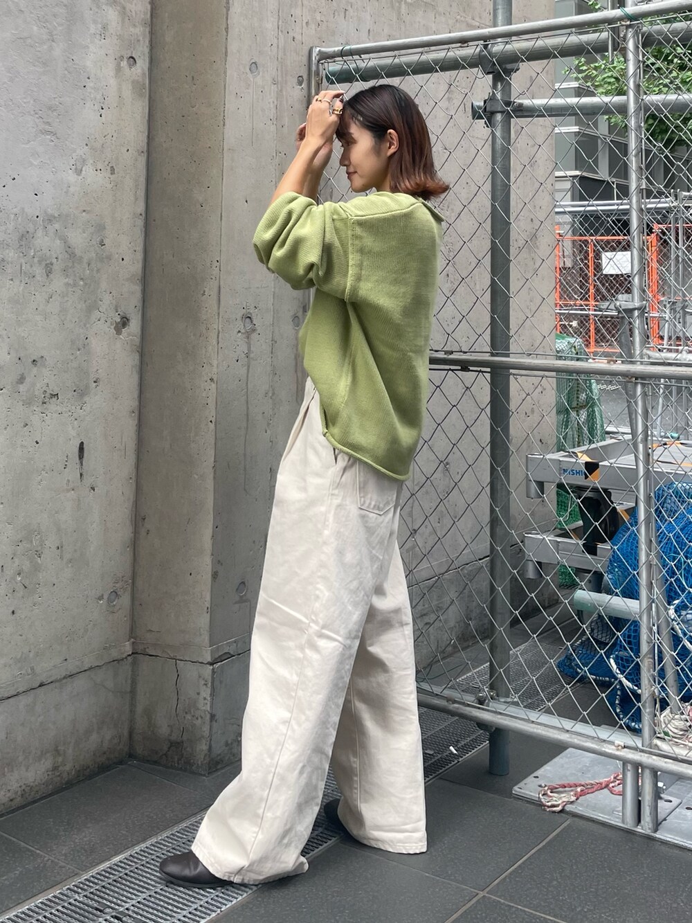 グリーン系のニット/セーター、ホワイト系のTシャツ/カットソー、ホワイト系のデニムパンツを着用したレディースの秋コーディネートの2枚目の写真