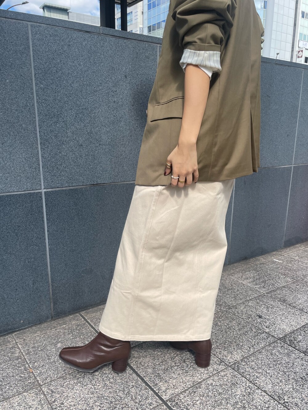 ベージュ系のテーラードジャケット、ホワイト系のTシャツ/カットソー、ベージュ系のスカートを着用したレディースの秋コーディネートの6枚目の写真