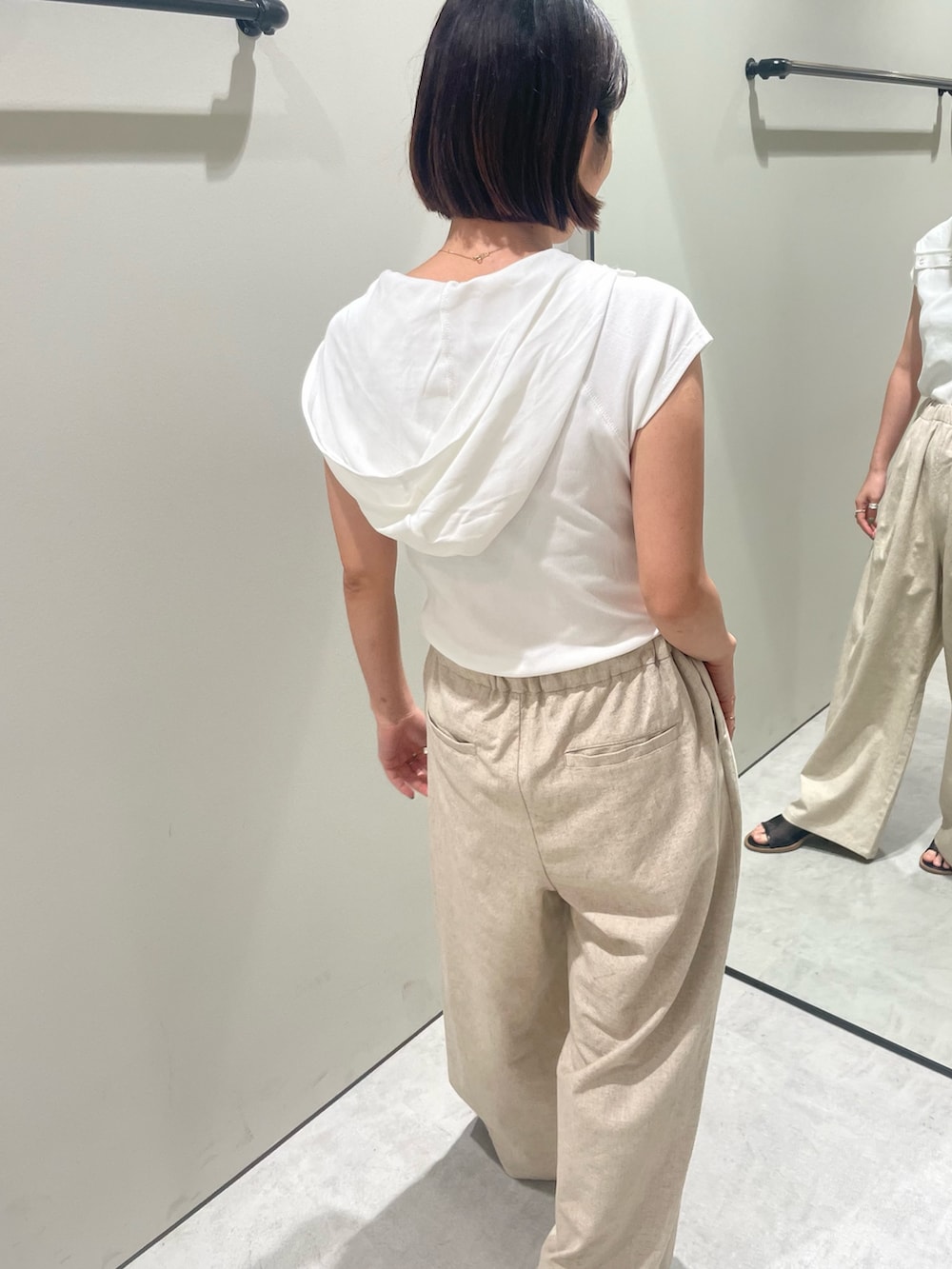 ホワイト系のTシャツ/カットソー、ベージュ系のその他パンツ、ブラック系のサンダルを着用したレディースの夏コーディネートの3枚目の写真