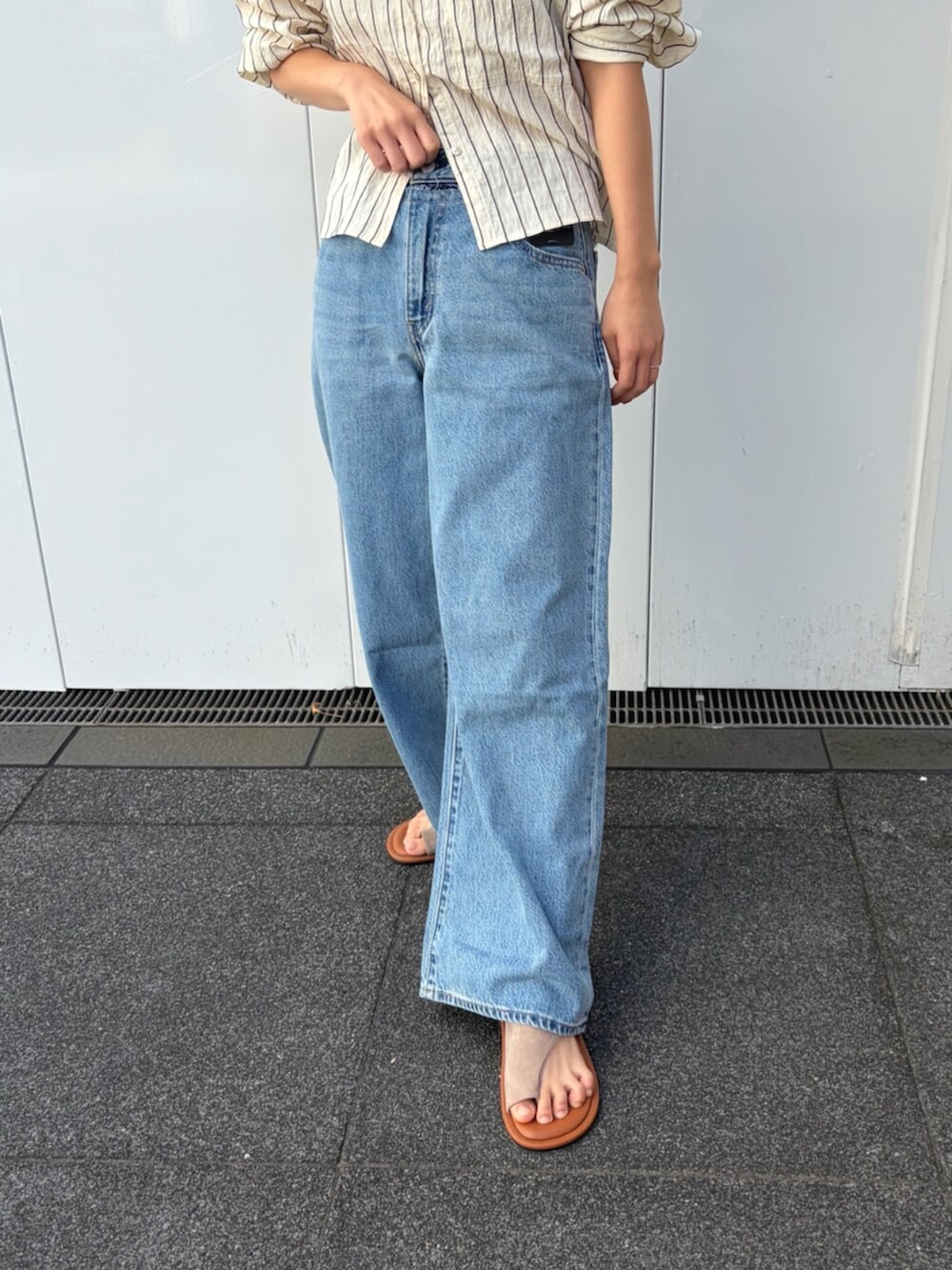 ブルー系のシャツ/ブラウス、ブルー系のデニムパンツを着用したレディースの夏コーディネートの6枚目の写真