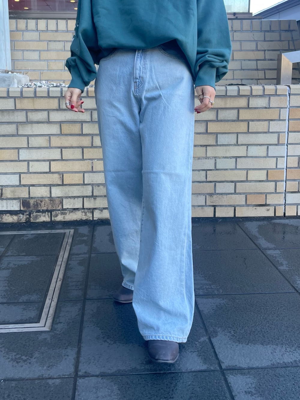 グリーン系のスウェット、ブルー系のデニムパンツを着用したレディースの冬コーディネートの5枚目の写真