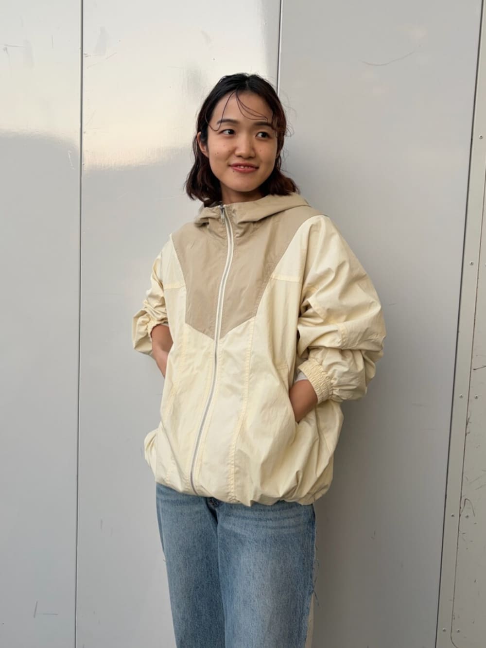 ホワイト系のブルゾン、ブルー系のデニムパンツ、ブラウン系のブーツを着用したレディースの秋コーディネートの4枚目の写真