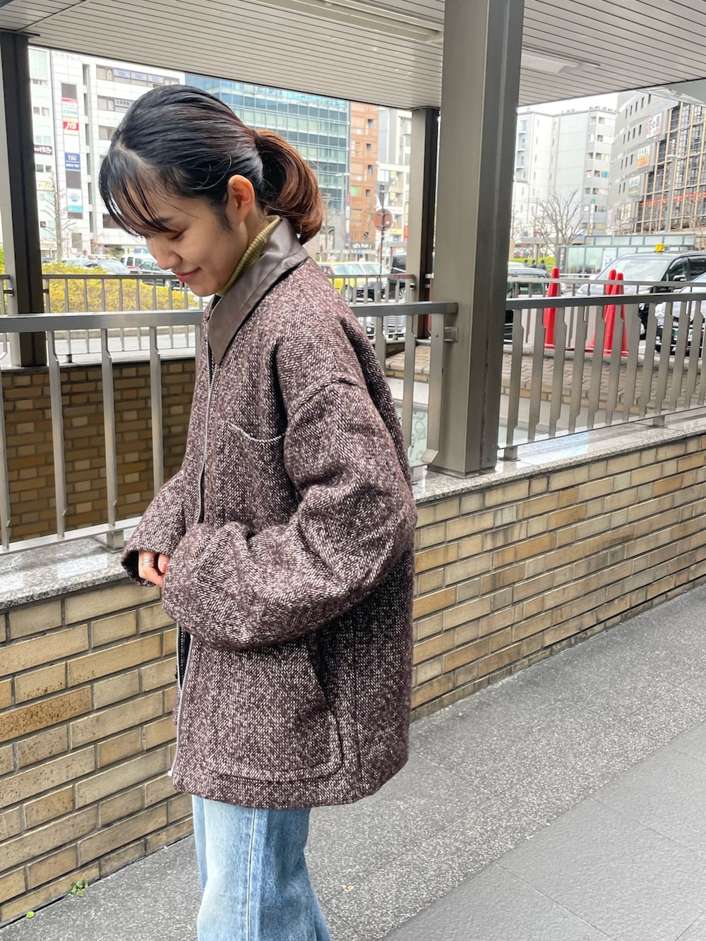 イエロー系のニット/セーター、ブラウン系のブルゾン、ブルー系のデニムパンツを着用したレディースの冬コーディネートの4枚目の写真