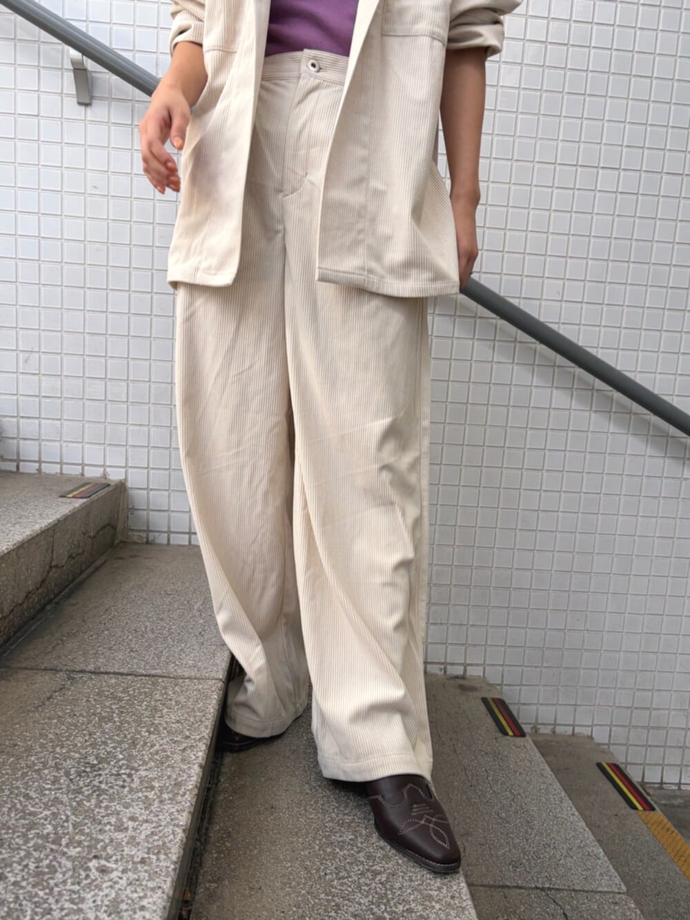 パープル系のタンクトップ、ホワイト系のブルゾン、ホワイト系のその他パンツを着用したレディースの夏コーディネートの6枚目の写真