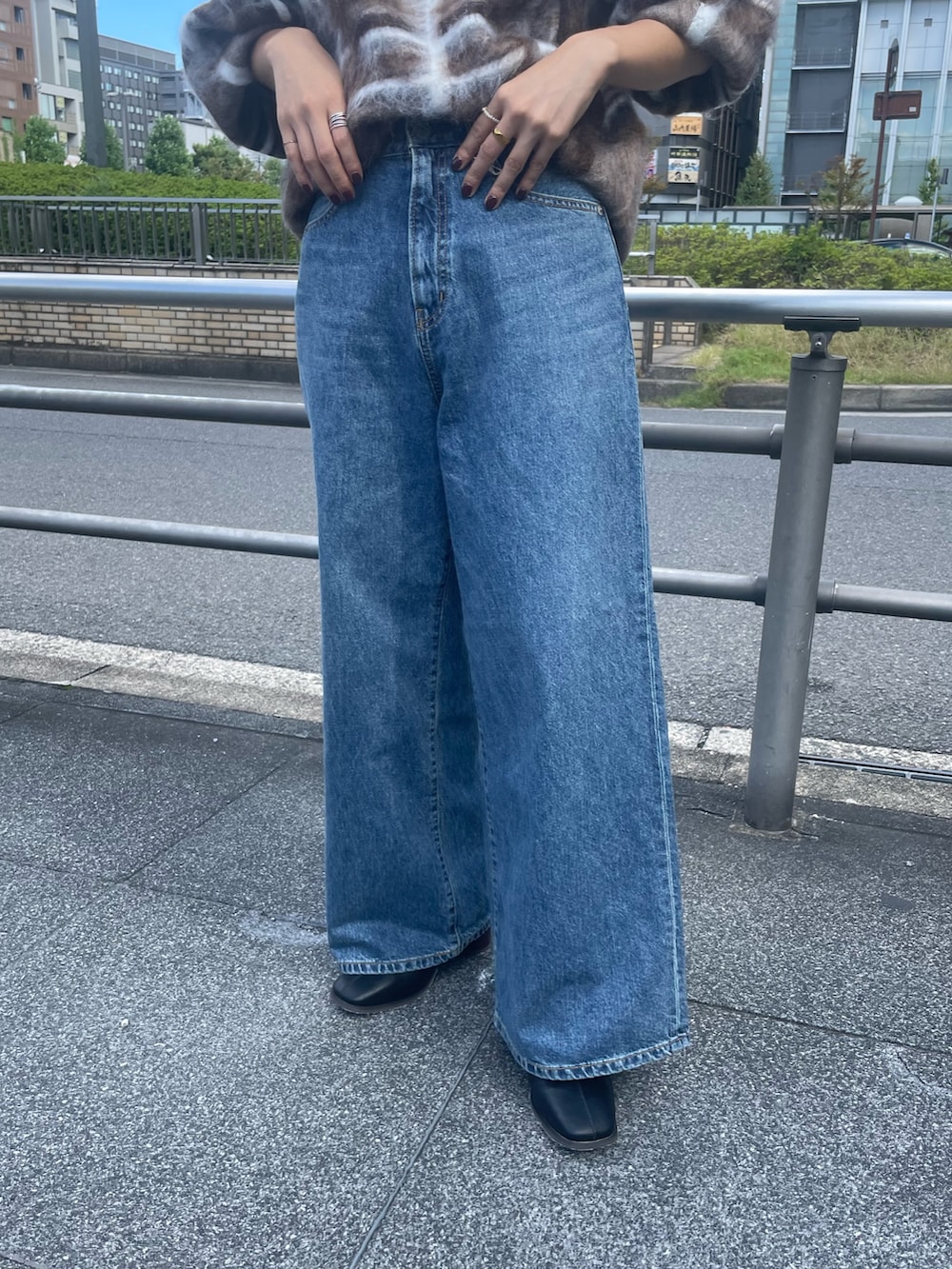 ブラウン系のニット/セーター、ブルー系のデニムパンツ、ブラック系のブーツを着用したレディースの秋コーディネートの5枚目の写真