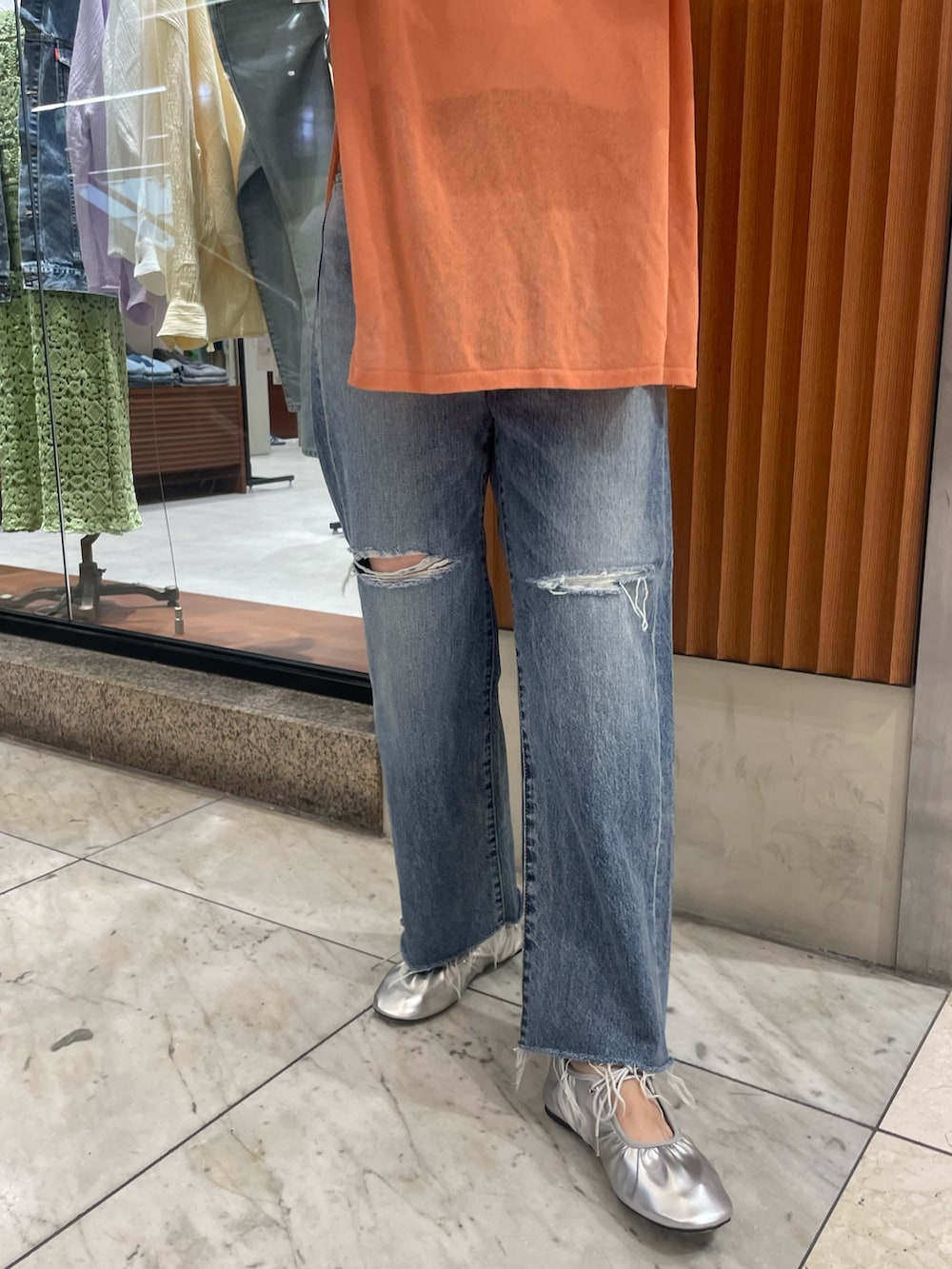 オレンジ系のニット/セーター、ブルー系のデニムパンツ、シルバー系のバレエシューズを着用したレディースの春コーディネートの5枚目の写真