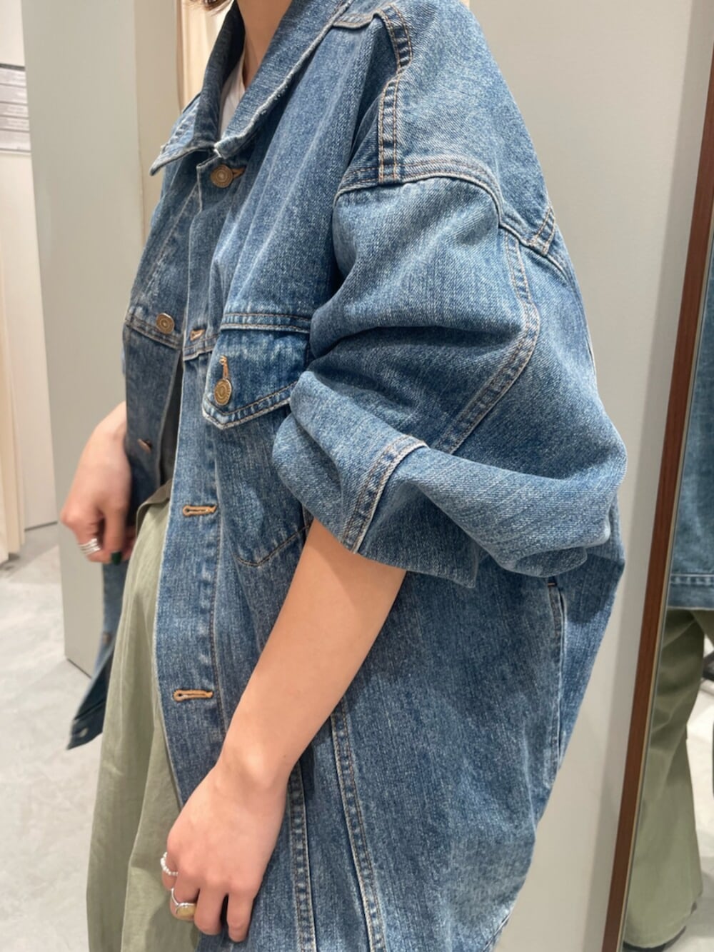 ブルー系のデニムジャケット、グリーン系のその他パンツ、ブラック系のスニーカーを着用したレディースの春コーディネートの6枚目の写真