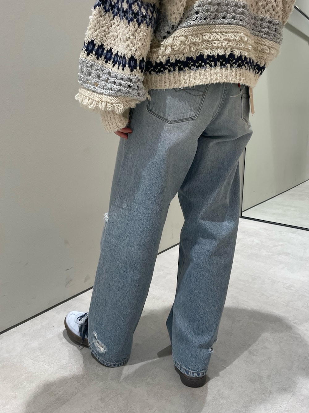 ホワイト系のニット/セーター、ブルー系のデニムパンツを着用したレディースの冬コーディネートの6枚目の写真