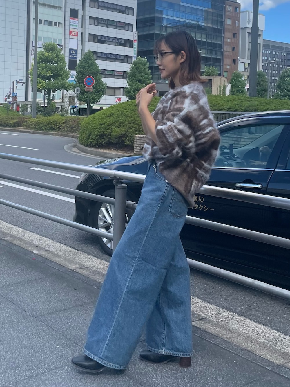 ブラウン系のニット/セーター、ブルー系のデニムパンツ、ブラック系のブーツを着用したレディースの秋コーディネートの2枚目の写真