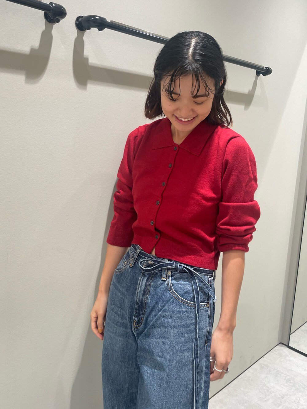 レッド系のカーディガン/ボレロ、ブルー系のデニムパンツを着用したレディースの秋コーディネートの6枚目の写真