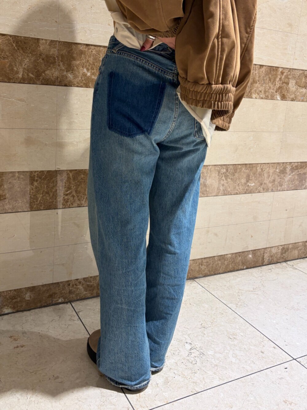 ベージュ系のシャツ/ブラウス、ブラウン系のブルゾン、ブルー系のデニムパンツを着用したレディースの秋コーディネートの6枚目の写真