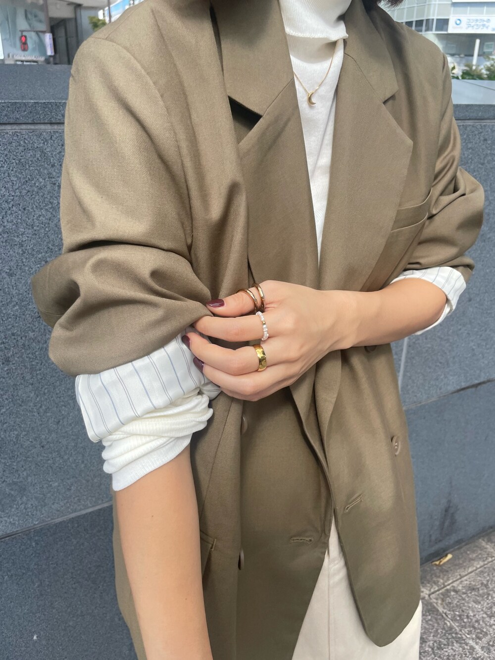 ベージュ系のテーラードジャケット、ホワイト系のTシャツ/カットソー、ベージュ系のスカートを着用したレディースの秋コーディネートの4枚目の写真