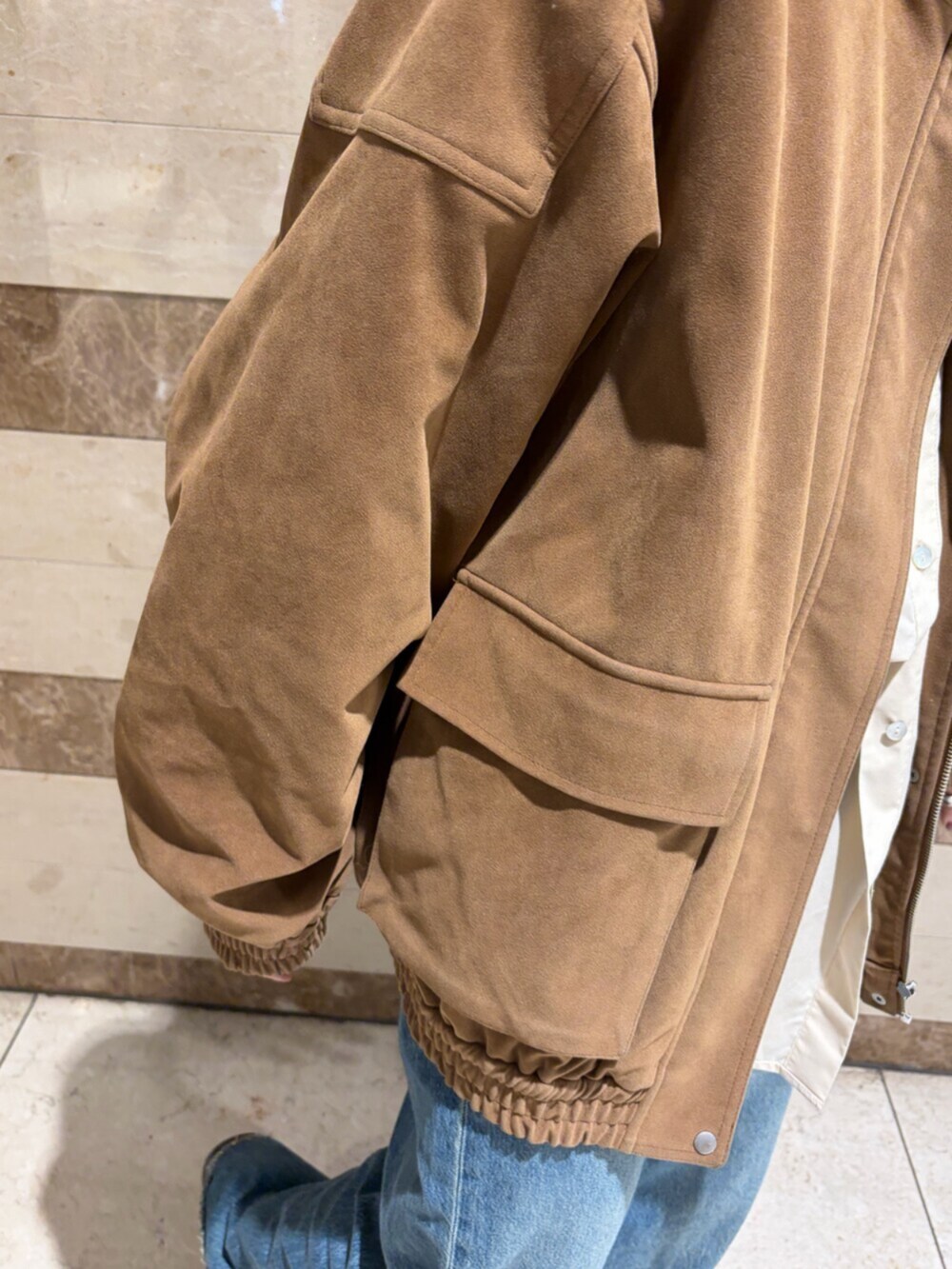 ベージュ系のシャツ/ブラウス、ブラウン系のブルゾン、ブルー系のデニムパンツを着用したレディースの秋コーディネートの4枚目の写真