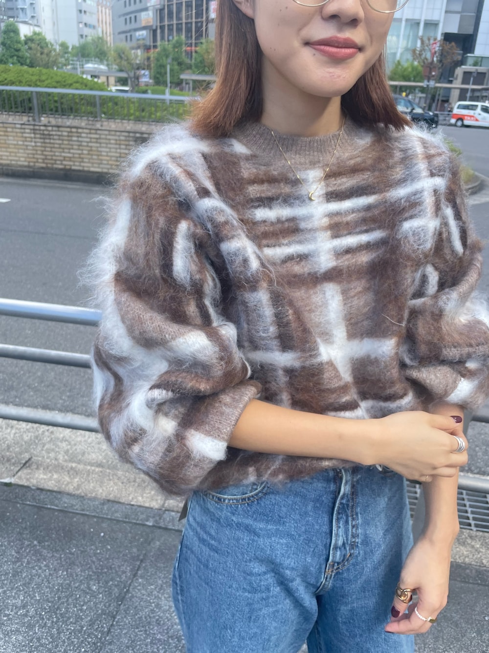 ブラウン系のニット/セーター、ブルー系のデニムパンツ、ブラック系のブーツを着用したレディースの秋コーディネートの4枚目の写真