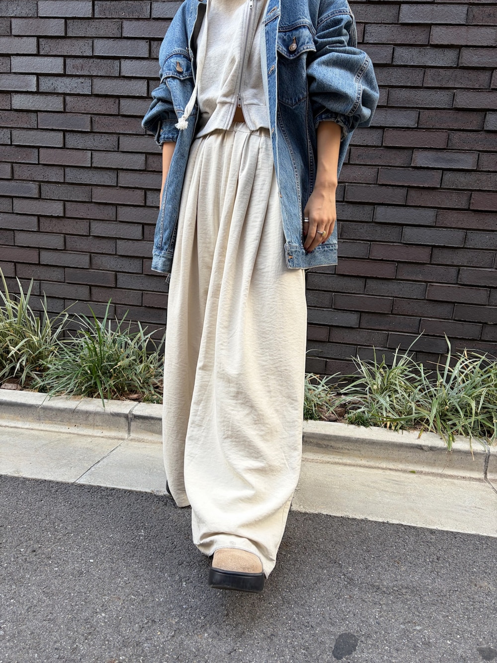 ブルー系のデニムジャケット、ホワイト系のその他パンツ、ホワイト系のパーカーを着用したレディースの秋コーディネートの4枚目の写真