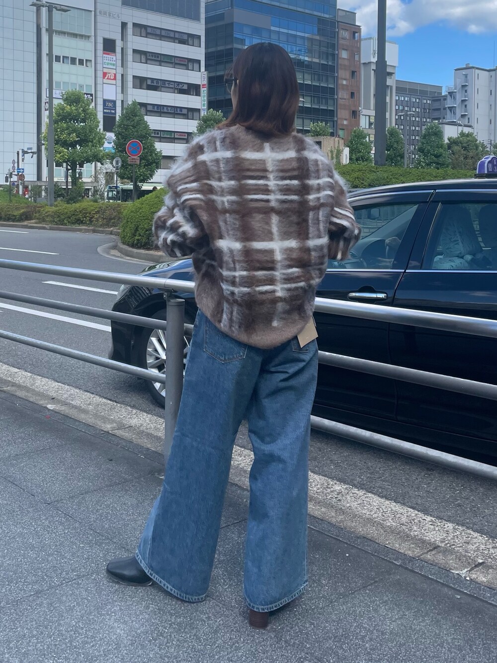 ブラウン系のニット/セーター、ブルー系のデニムパンツ、ブラック系のブーツを着用したレディースの秋コーディネートの3枚目の写真