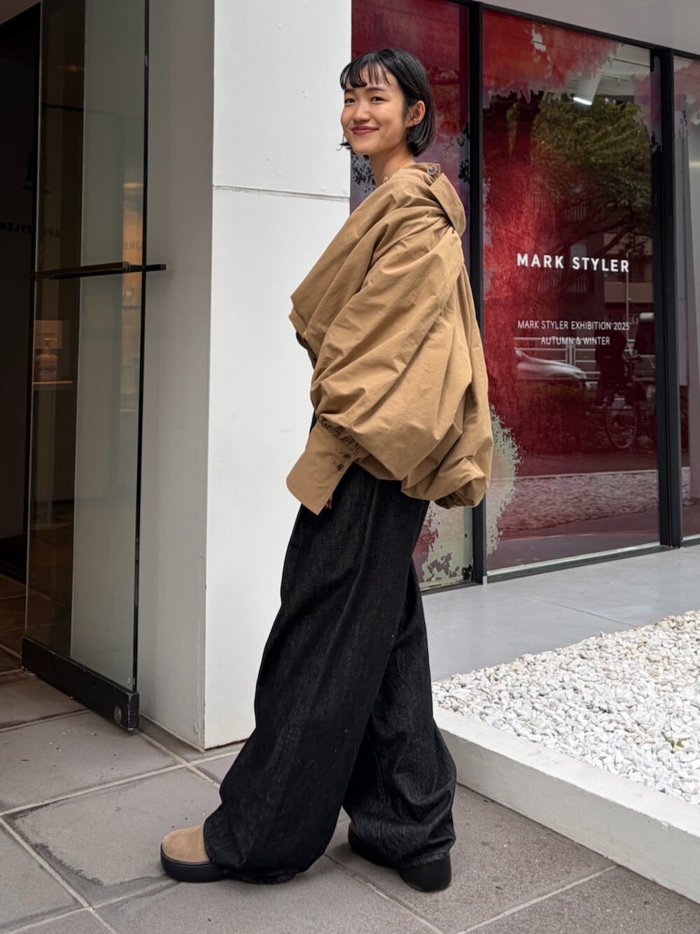 ベージュ系のブルゾン、グレー系のスウェット、ブラック系のデニムパンツを着用したレディースの秋コーディネートの2枚目の写真