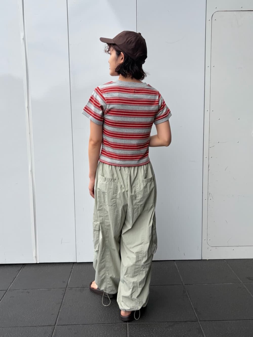 レッド系のTシャツ/カットソー、グリーン系のその他パンツ、ブラウン系のキャップを着用したレディースの夏コーディネートの3枚目の写真