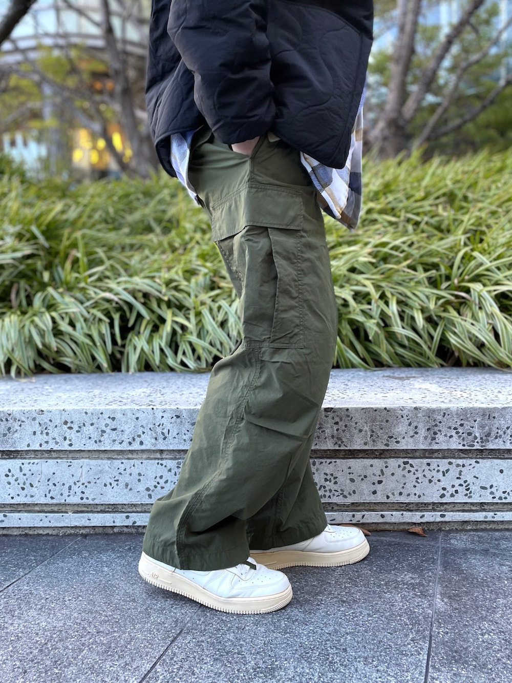 グリーン系のカーゴパンツ、ホワイト系のスニーカー、ブラック系のダウンジャケット/コートを着用したメンズの冬コーディネートの3枚目の写真