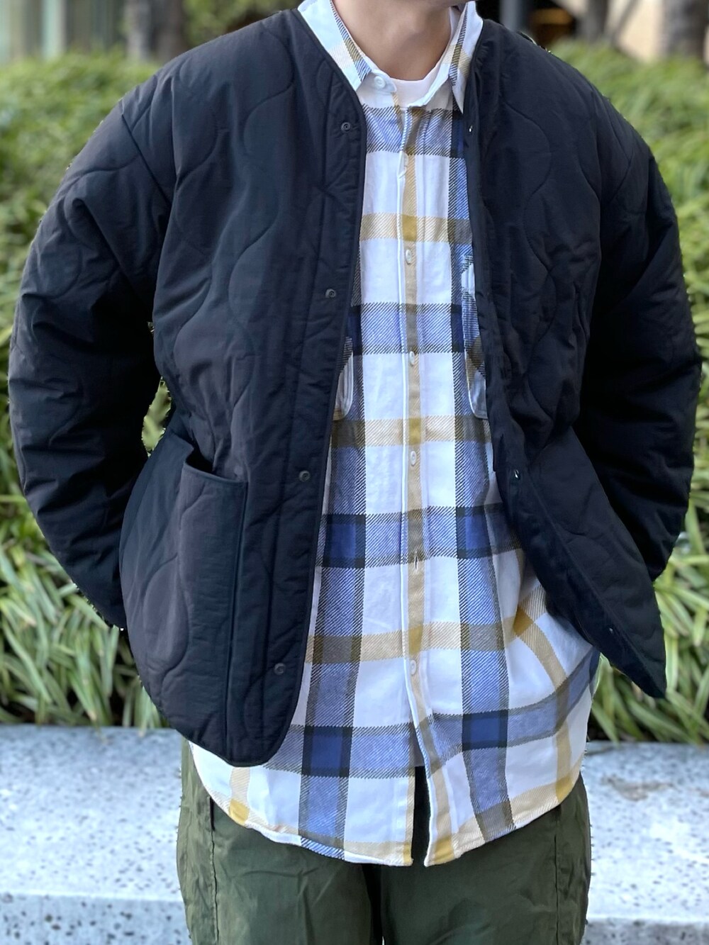 グリーン系のカーゴパンツ、ホワイト系のスニーカー、ブラック系のダウンジャケット/コートを着用したメンズの冬コーディネートの2枚目の写真