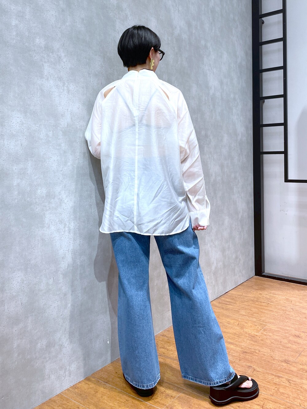 ホワイト系のシャツ/ブラウス、ブラック系のサンダル、ブルー系のデニムパンツを着用したレディースの夏コーディネートの2枚目の写真