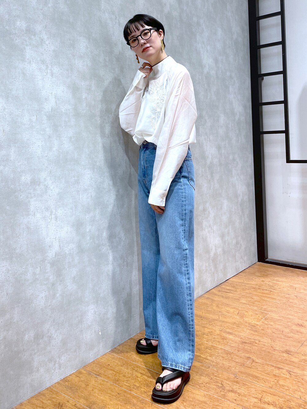 ホワイト系のシャツ/ブラウス、ブラック系のサンダル、ブルー系のデニムパンツを着用したレディースの夏コーディネートの4枚目の写真