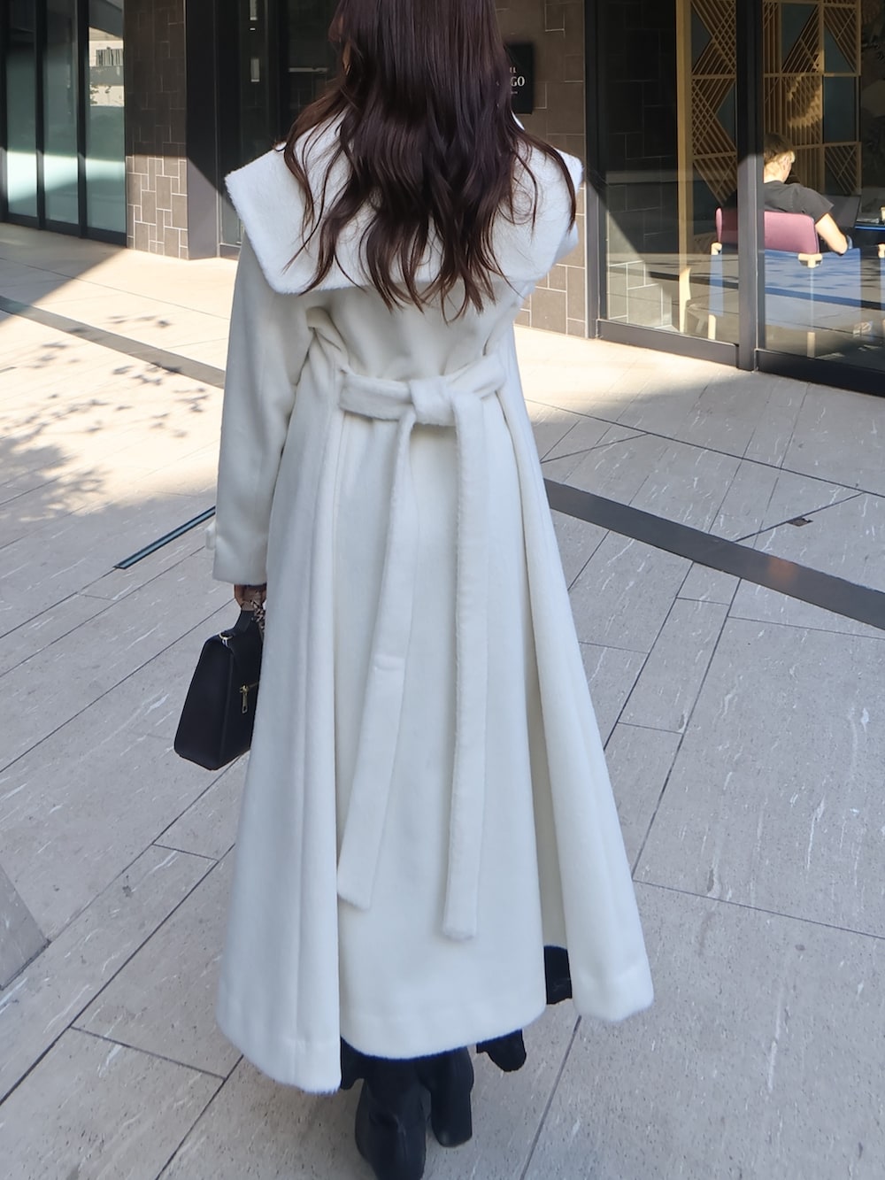 ホワイト系のその他アウター、ブラック系のワンピース、ブラウン系のショルダーバッグを着用したレディースの冬コーディネートの3枚目の写真