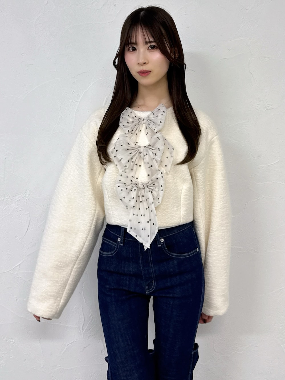 ホワイト系のブルゾン、ブルー系のデニムパンツを着用したレディースの冬コーディネートの5枚目の写真