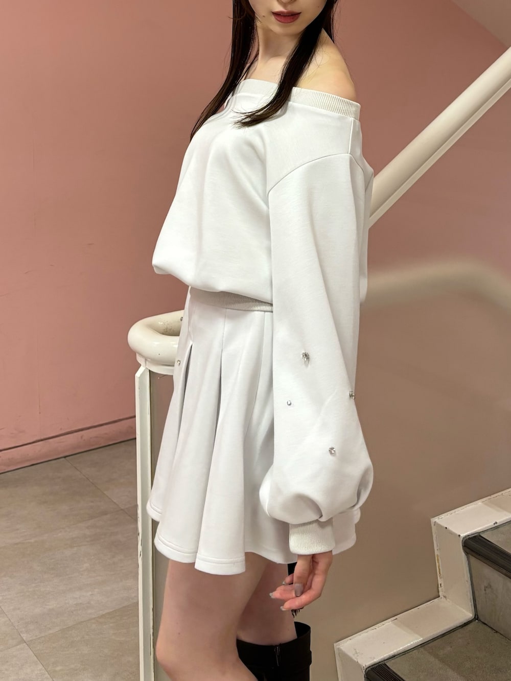 ホワイト系のスウェット、ホワイト系のスカート、ブラウン系のブーツを着用したレディースの秋コーディネートの6枚目の写真