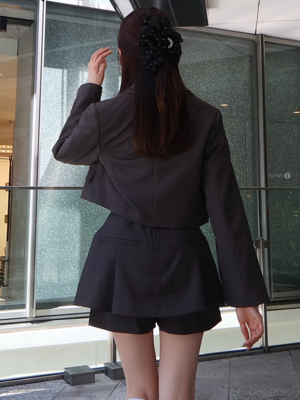 グレー系のスカート、グレー系のテーラードジャケット、イエロー系のシャツ/ブラウスを着用したレディースの秋コーディネートの5枚目の写真