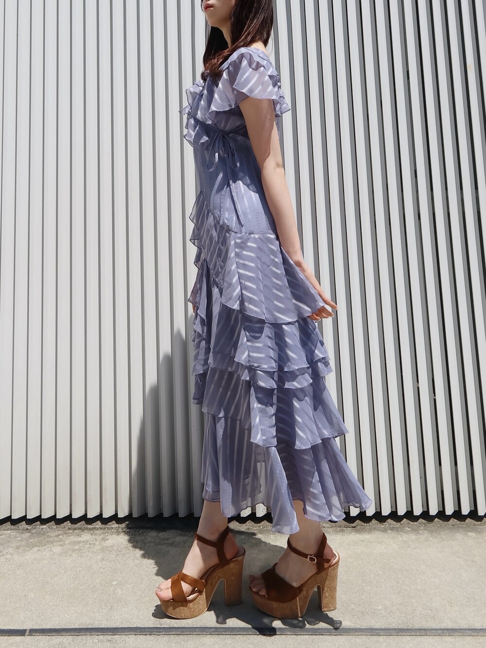 ブラウン系のサンダル、ブラウン系のハンドバッグ、ブルー系のワンピースを着用したレディースの夏コーディネートの2枚目の写真